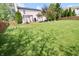 Backyard featuring a lush lawn and mature trees, with a patio and deck visible in the background at 12115 Flagstone Dr, Fishers, IN 46037