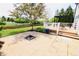 Spacious backyard with a stone patio, dining set, and view of the pond and landscaping at 12115 Flagstone Dr, Fishers, IN 46037