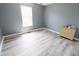Empty bedroom with light wood plank floors and window for optimal natural lighting at 12115 Flagstone Dr, Fishers, IN 46037
