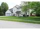 Inviting two-story home with a lush green lawn and mature shade tree at 12115 Flagstone Dr, Fishers, IN 46037