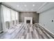 Bright living room with fireplace, large windows, and modern gray plank flooring at 12115 Flagstone Dr, Fishers, IN 46037
