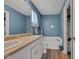 Well-lit bathroom with blue walls, dual sinks, and tub at 12256 Sagamore Woods Dr, Fishers, IN 46037