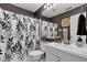 Stylish bathroom with a leaf-patterned shower curtain, vanity, and framed mirror at 12256 Sagamore Woods Dr, Fishers, IN 46037