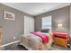 Cozy bedroom featuring a single bed, neutral walls, window, and simple decor at 12256 Sagamore Woods Dr, Fishers, IN 46037