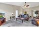 Comfortable living room area with neutral walls and a ceiling fan, seamlessly connected to the dining area at 12256 Sagamore Woods Dr, Fishers, IN 46037