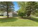 Well-kept home featuring a lush green lawn, mature trees, and a quaint backyard at 129 Rosewood Dr, Cicero, IN 46034