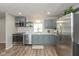Bright kitchen with stainless steel appliances, gray cabinets, and hardwood floors at 129 Rosewood Dr, Cicero, IN 46034