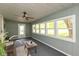 Bright sunroom with large windows, neutral decor, and a ceiling fan offers relaxing views of the outdoors at 129 Rosewood Dr, Cicero, IN 46034