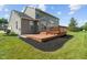 Back of home features a tiered wood deck, green lawn, and mature trees at 13553 Lorenzo Blvd, Carmel, IN 46074