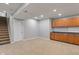 Spacious finished basement area with cabinets and a carpeted staircase at 13553 Lorenzo Blvd, Carmel, IN 46074