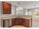 Kitchen with wood cabinets, stainless steel dishwasher, and view to dining area at 13553 Lorenzo Blvd, Carmel, IN 46074