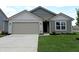 Charming one-story home featuring a well-manicured lawn and attached two-car garage at 1400 Bluebonnet Pl, Shelbyville, IN 46176