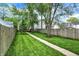 The perfectly manicured lawn in the backyard runs along a walkway that passes between neighboring fences at 1434 Laurel St, Indianapolis, IN 46203