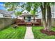 Charming backyard featuring a wooden deck, lush green grass, and a concrete walkway leading to the house at 1434 Laurel St, Indianapolis, IN 46203
