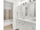 Bathroom featuring a double vanity, tiled shower, and well-lit mirrors at 1434 Laurel St, Indianapolis, IN 46203
