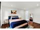 Comfortable bedroom with hardwood floors, minimalist decor, and an ensuite bathroom at 1434 Laurel St, Indianapolis, IN 46203