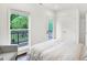 Sunlit bedroom with walkout deck access, hardwood floors, and a comfortable chair at 1434 Laurel St, Indianapolis, IN 46203