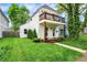 Two-story home with a front balcony, beautiful lawn, and meticulously maintained landscaping at 1434 Laurel St, Indianapolis, IN 46203