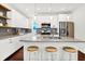 Modern kitchen with white cabinets, stainless steel appliances, gray backsplash, and large island with barstool seating at 1434 Laurel St, Indianapolis, IN 46203