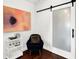 Cozy sitting area with artwork, a stylish chair, a bar cart, and a frosted glass sliding barn door at 1434 Laurel St, Indianapolis, IN 46203