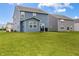 Spacious backyard featuring the home's blue exterior, a patio with a grill, and a well-manicured lawn at 1464 Buckland Ct, Avon, IN 46123