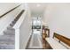 Bright hallway with hardwood floors leads to a staircase and a view of the living room at 1464 Buckland Ct, Avon, IN 46123