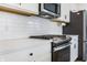 Close up of kitchen with stainless steel stove and appliances, white cabinets, and subway tile backsplash at 1464 Buckland Ct, Avon, IN 46123
