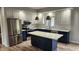 Modern kitchen with stainless steel appliances, white and navy cabinets, and a center island with marble countertop at 1536 Copperwood Pl, Carmel, IN 46033
