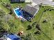 Aerial view of backyard showcasing pool, patio, playground, and lush lawn at 15378 Dorman Ct, Fishers, IN 46040