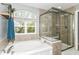 Bathroom with a tub under an arched window and a glass-enclosed shower at 15378 Dorman Ct, Fishers, IN 46040