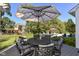 Outdoor dining set with a striped umbrella on a wooden deck, surrounded by lush greenery at 15378 Dorman Ct, Fishers, IN 46040