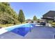 Outdoor pool area with clear blue water and modern patio furniture in a landscaped backyard at 15378 Dorman Ct, Fishers, IN 46040