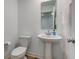 Powder room featuring a pedestal sink, toilet, and neutral walls and flooring at 17237 Rancorn Pl, Westfield, IN 46074