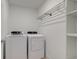 Bright laundry room with modern washer and dryer units and built-in shelving for storage at 17237 Rancorn Pl, Westfield, IN 46074