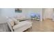 Bright living room with hardwood floors, a white sofa and a large television at 17237 Rancorn Pl, Westfield, IN 46074