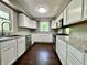 Galley kitchen features white cabinets, dark flooring and modern stainless appliances at 1760 Pumpkinvine Hill Rd, Martinsville, IN 46151