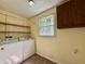 Practical laundry room with washer, dryer, storage shelves, and a bright window at 1760 Pumpkinvine Hill Rd, Martinsville, IN 46151