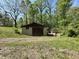 Exterior view of a large outbuilding with adjacent greenhouse on a verdant lot at 1760 Pumpkinvine Hill Rd, Martinsville, IN 46151