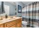 Bathroom with wood vanity, blue accent walls and a blue and brown patterned shower curtain at 1787 Halifax St, Carmel, IN 46032