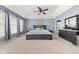 Spacious bedroom with a king-sized bed, tray ceilings, and large windows with neutral curtains at 1787 Halifax St, Carmel, IN 46032