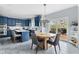 Spacious kitchen with island, dining area, blue cabinets, stainless appliances, and access to a deck at 1787 Halifax St, Carmel, IN 46032