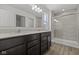 A bright bathroom features a double vanity, large mirror, tiled floors, and glass door walk-in shower at 1874 Victor Higgins Dr, Shelbyville, IN 46176