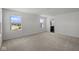 A bright bedroom boasts neutral carpet, white walls, two windows and an open doorway to the on-suite bathroom at 1874 Victor Higgins Dr, Shelbyville, IN 46176