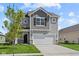 Two-story home featuring a two-car garage, stone accents and gray siding at 1874 Victor Higgins Dr, Shelbyville, IN 46176