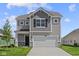 Two-story home featuring a two-car garage, stone accents and gray siding at 1874 Victor Higgins Dr, Shelbyville, IN 46176