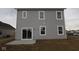 View of the home's gray vinyl siding, windows, and sliding glass doors to the back patio at 1874 Victor Higgins Dr, Shelbyville, IN 46176