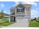 Two-story home featuring a two-car garage, stone accents and gray siding at 1874 Victor Higgins Dr, Shelbyville, IN 46176