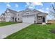 Charming two-story home with gray siding, a well-kept lawn and an attached two car garage at 1874 Victor Higgins Dr, Shelbyville, IN 46176