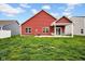 Exterior shot of a home's backyard, featuring a cozy covered patio area and a spacious green lawn at 2006 Monticlair Ln, Columbus, IN 47201