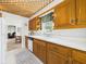 Bright kitchen showcases wood cabinets, white countertops, and view to additional living area at 2011 Sheffield Ave, Anderson, IN 46011